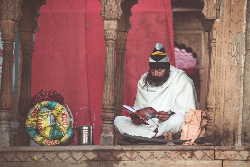 Sadhu reviewing ancient text on the banks of the Yamuna river, Vrindavan, India